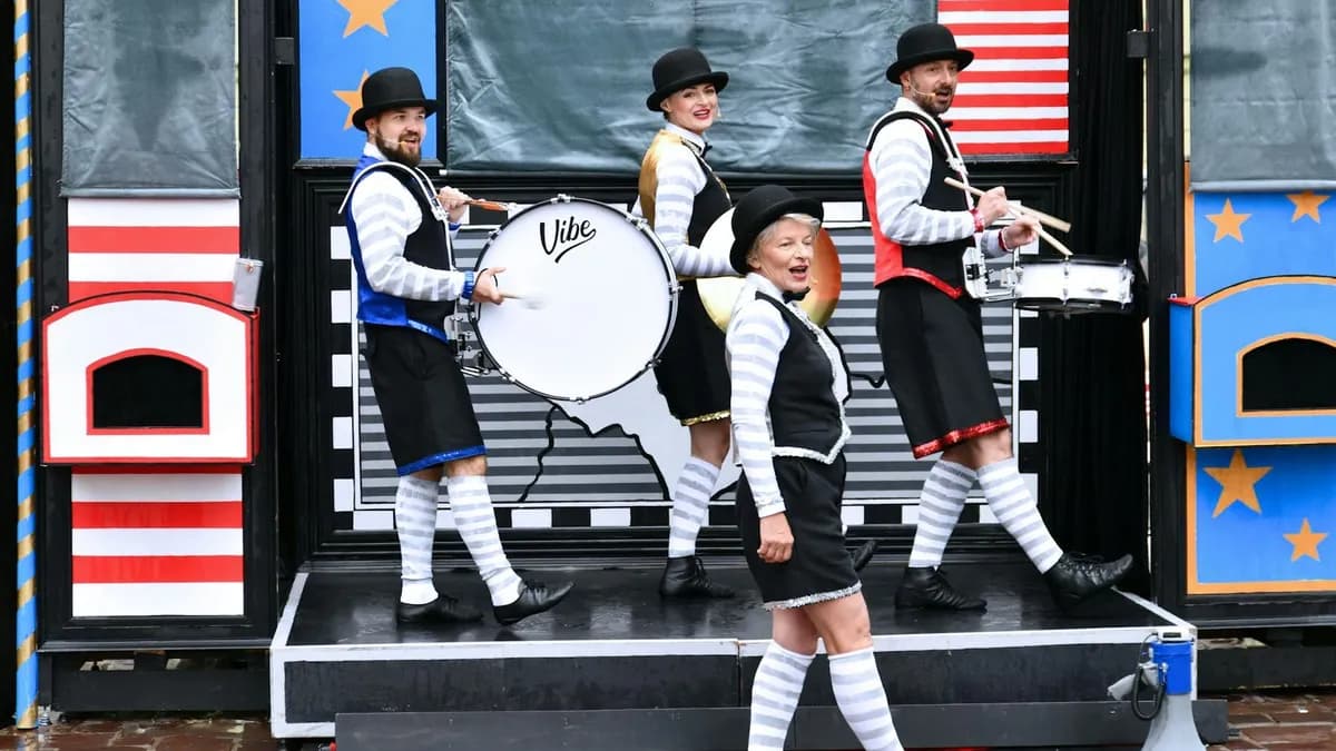 Vibrant street performers dressed in costumes playing musical instruments during a parade.