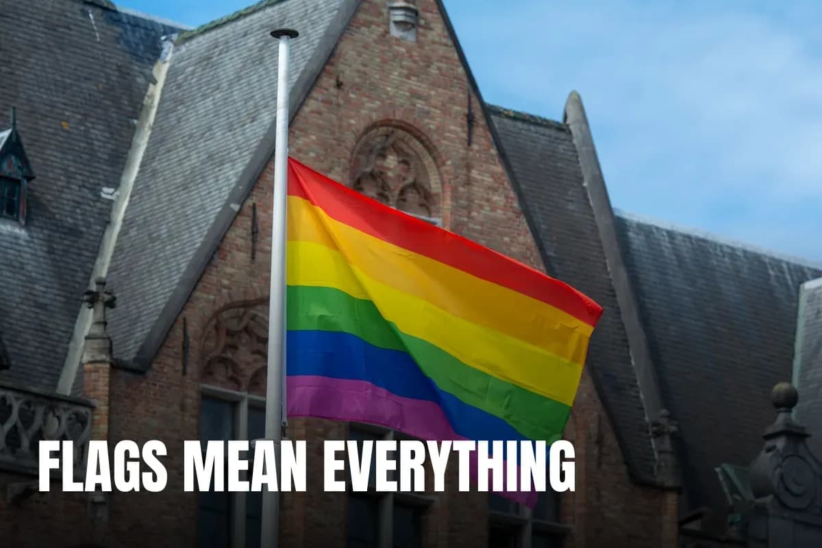 Bright rainbow pride flag waving against a historic architectural building, symbolizing diversity and inclusion.