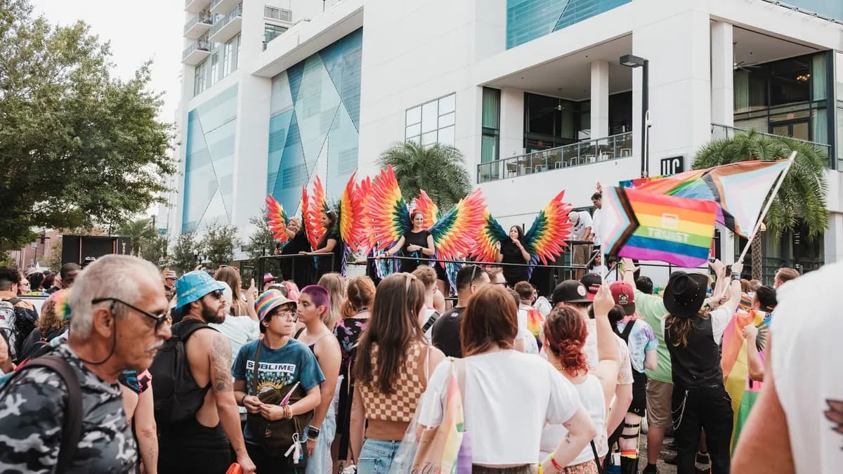 LGBT community celebrating pride with vibrant flags and costumes in an outdoor parade setting.