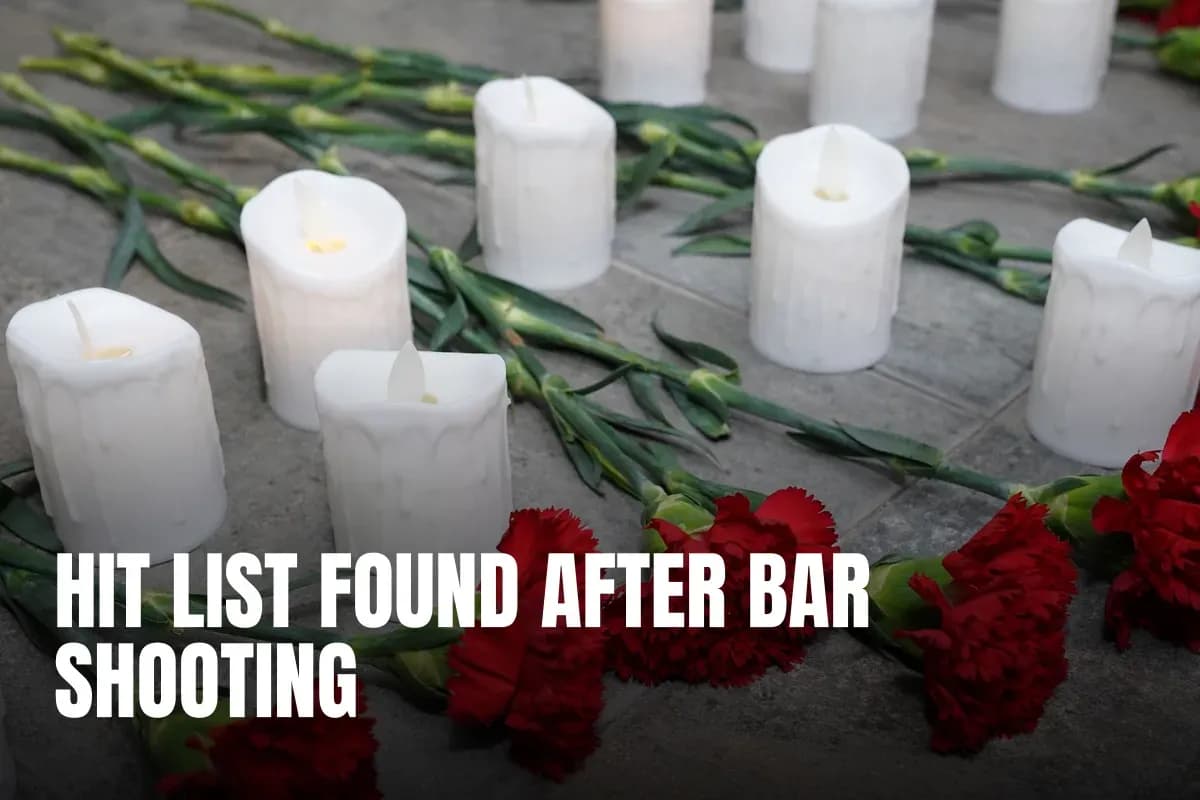 Arrangement of red carnations and white candles on a stone surface, symbolizing peace and remembrance.