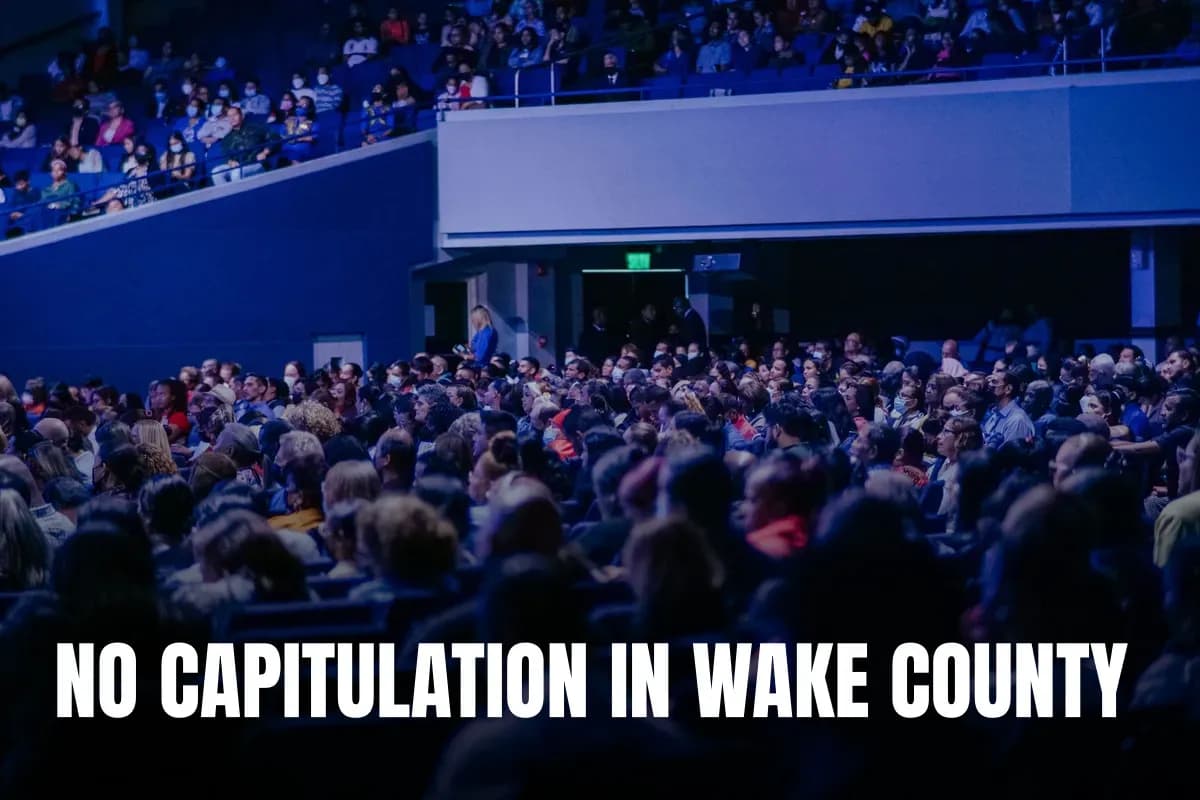 A crowded conference hall with diverse audience attentively listening to a speaker.